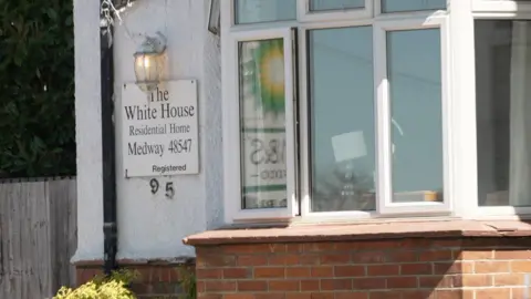 A close up of a sign on a residential building which reads "The White House Residential Home, Medway" 