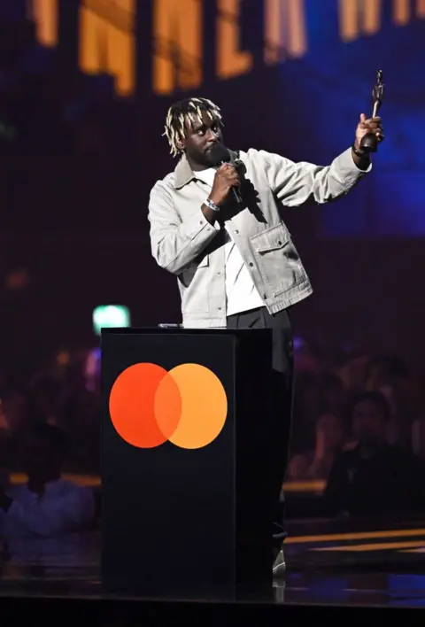 Getty Images Myles Smith on stage with his Brit award for rising star