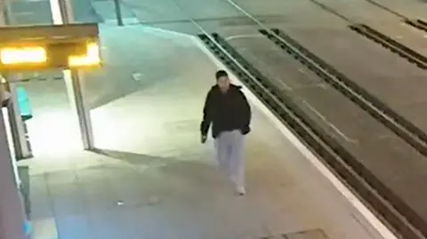 A CCTV image of a man at a tram stop