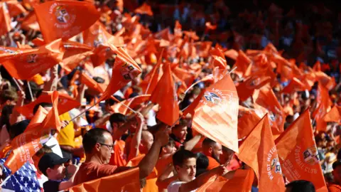Reuters Orange banners and flags flown by Luton fans in the stands of Wembley