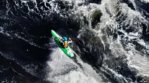 A kayaker navigating powerful white-water rapids.