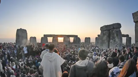 Huge crowd by Stonehenge watching the stones as the sunrises between them.