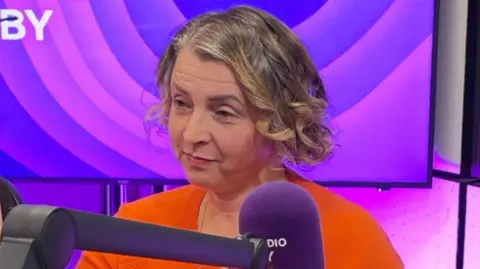 Kacper Misiarz/BBC Picture of Agnes Adkins in the BBC Radio Derby studio. She is wearing a red top and has a fair-coloured bob haircut.