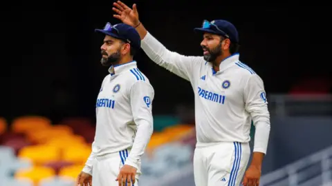 Getty Images India's Rohit Sharma (R) gestures next to Virat Kohli during day five of the third cricket Test match between Australia and India at The Gabba in Brisbane