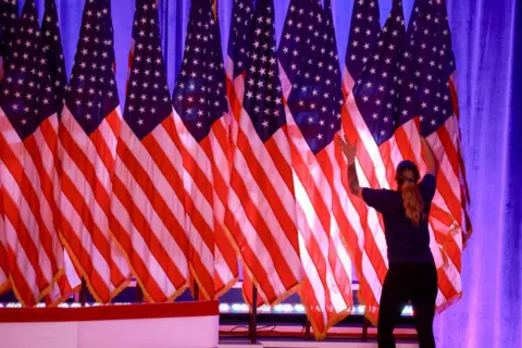 Joe Raedle/Getty Images A worker prepares the stage for the election night watch party for Republican presidential nominee former President Donald Trump at the Palm Beach County Convention Center on November 05, 2024, in West Palm Beach, Florida. Today, voters cast their ballots to determine whether Republican nominee former President Donald Trump or Democratic nominee Vice President Kamala Harris will become the next President of the United States.