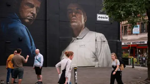 Reuters People walk past a mural of the Gallagher brothers in Manchester