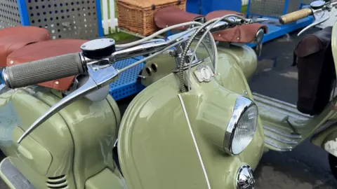a vintage two-seater Lambretta in green with brown saddles