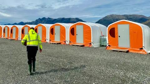 Tenda akomodasi berwarna oranye dan putih di tambang Nalunaq