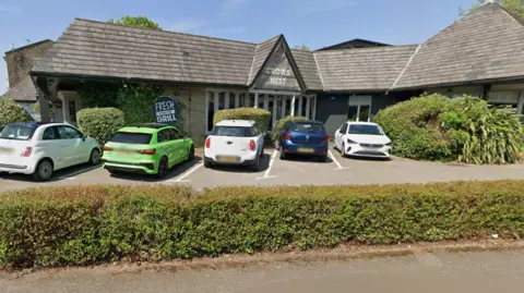 The Crow's Nest Pub exterior with cars parked in the car park in front of the entrance.