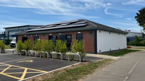 Buckhurst pavilion building with disable parking bay outside. The building is a single story with solar panels.