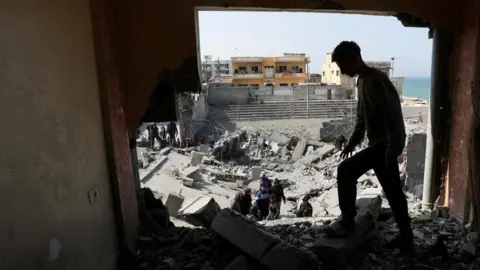 Reuters Palestinians inspect the site of an Israeli strike on a residential building, in Deir al-Balah in central Gaza.