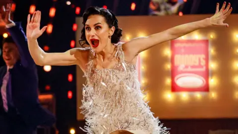 Amber Davies dancing in Strictly in a white sparkly dress