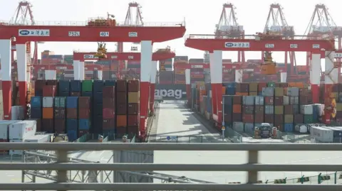 Reuters Gantry cranes stand near shipping containers at Yangshan Port outside of Shanghai, China