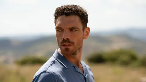 BBC/Left Bank Pictures/James Stack James Nelson-Joyce wearing a blue polo shirt while playing Michael Kavanagh in the BBC One drama This City Is Ours