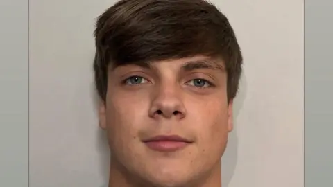 Family handout A passport-style picture of Harry, he has short brown hair swept to the side across his forehead.