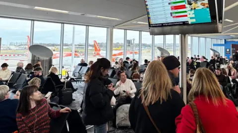passengers looking at a screen in Edinburgh Airport