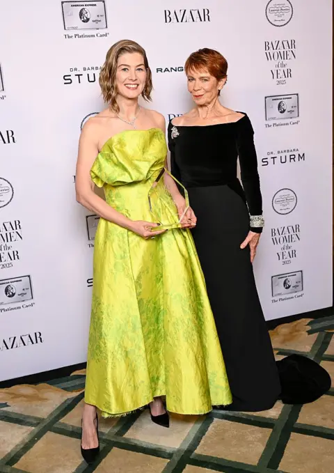Getty Images Rosamund Pike, winner of Theatre Actress of The Year Award, poses with Celia Imrie in the Winner's Room during Harper's Bazaar Women Of The Year at Claridges Hotel on November 06, 2025 in London, England.