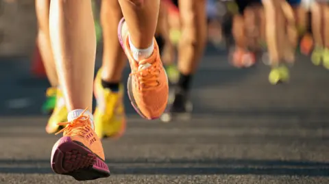 An image showing runners' legs in a race. 