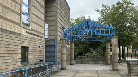 The entrance to Wolverhampton Crown Court. A blue rail is near the entrance. 