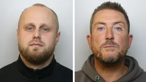 Avon and Somerset Police Police mugshots of Dennis on the left and Maine on the right. Dennis has short blonde hair and a beard and is wearing a black three quarter zip top. Maine has short brown hair and a patchy beard and is wearing a dark grey hoodie. They are both standing against a grey background with a neutral facial expression.