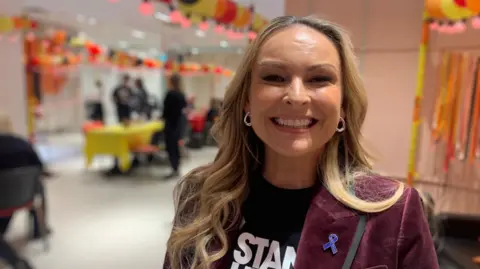 A woman smiles at the camera