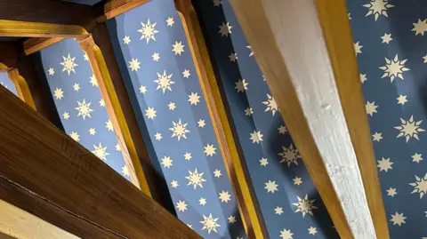 The ceiling of one of the chapels covered in blue paint with yellow stars which have been hand painted by conservators. 