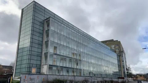 A large glass fronted apartment block