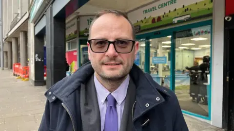 Anthony Carver-Smith stood outside the NCT Travel Centre on South Parade.