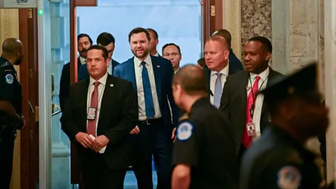 Man walks with security on both sides