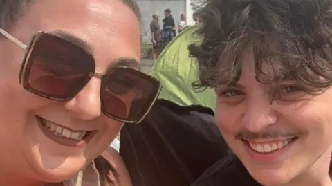 Contributed A close-up picture of Joshua Wallace and his mum's faces. They are both smiling at the camera with their heads close to each other. It's a sunny day and Corrin Wallace is wearing large sunglasses.