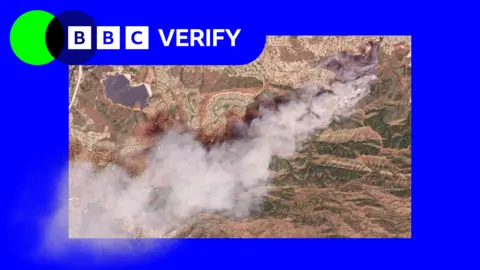 A satellite image with BBC Verify branding showing smoke rising from a fire south of Simi Valley