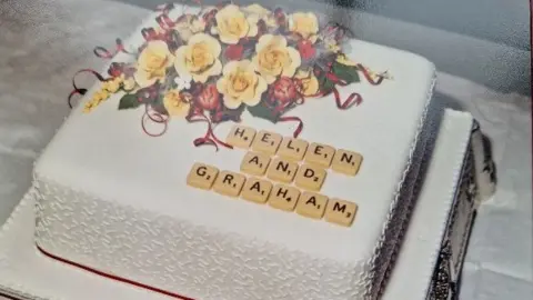 Graham and Helen Harding Helen and Graham scrabble theme wedding cake which says 'Helen and Graham' in scrabble tiles 