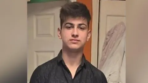 Family handout Darius Popan, who has medium-length brown hair and is wearing a grey shirt