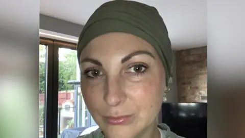 Supplied A woman looking down the lens of the camera. She is expressionless.