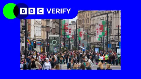Welsh flags and people in the centre of Cardiff's St Mary Street