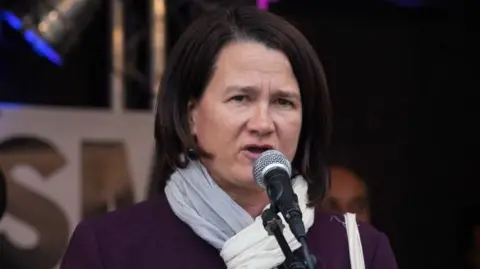 Catherine West speaks into a microphone in 2017.