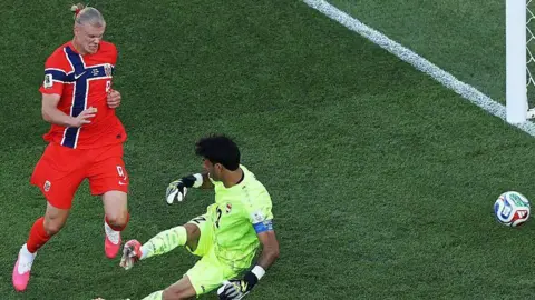 Norway forward Erling Haaland closes down Iraq goalkeeper Jalal Hassan, forcing a rushed clearance during a World Cup group-stage match