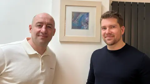 BBC Steve Gallant (left) and Darryn Frost in front of a picture by Anne Merritt, the mother of Jack Merritt