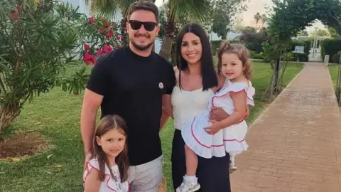 Supplied A family photo of a mum and dad and two young girls on holiday