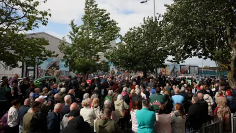 Reuters A large crowd of people are gathered outside for a rally. 