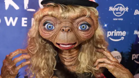 Heidi Klum in an impressive E.T. costume featuring big blue eyes and blond hair