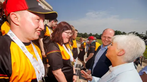 PA Media (Left to right) Special Olympics Ulster athletes Joshua McKiernan and Claire O’Neill speak with Junior Minister Joanne Bunting and Communities Minister Gordon Lyons as they are welcomed to Parliament Buildings on the Stormont Estate in Belfast.