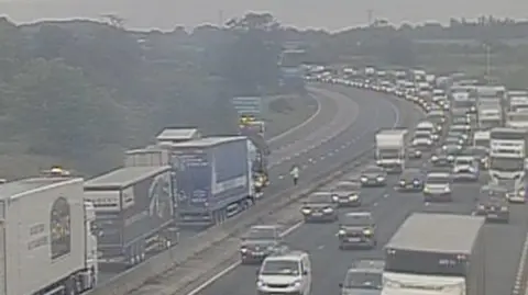 Highways England A high up view of the traffic stopped on the lanes of the motorway