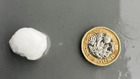 A hailstone next to a £1 coin