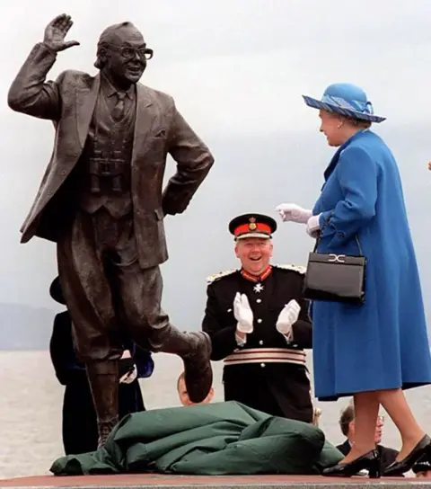PA Media The statue of comedian Eric Morecambe being unveiled on Morecambe Promenade by the Queen on 23 July 1999