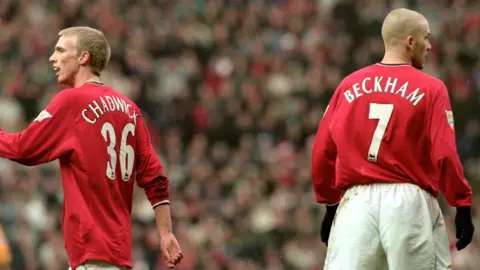 Getty Images Luke Chadwick, picture mid stride wearing his number 36 Manchester United shirt. David Beckham, to the right of Chadwick, is facing away from camera, with his Red Manchester United  number 7 shirt on full display.