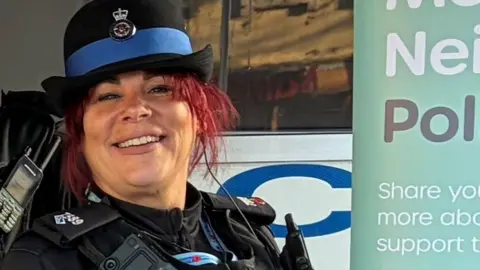  Michelle-Zoe Woodward in standard PCSO uniform near a display poster.