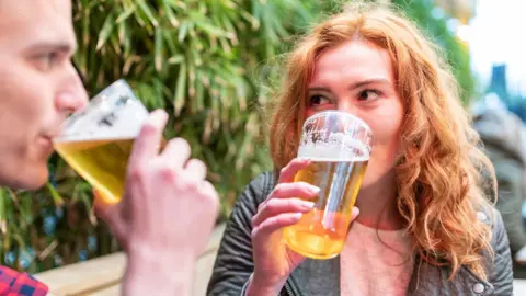 A man and a woman drinking alcohol-free beer in a beer garden