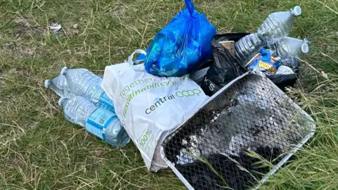 Andrew Trickey Water bottles, a barbecue and carrier bags full of rubbish