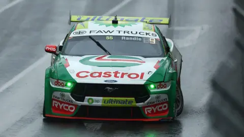 A green Ford racing car with a Castrol sponsorship logo on the bonnet. 